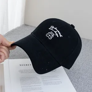 Close-up of black cotton baseball cap with white bear embroidery and artistic text
