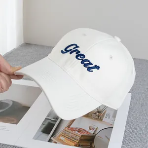Close-up of white cotton baseball cap with blue Great embroidery and curved brim