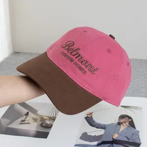 Detalle de gorra de béisbol bicolor con corona rosa, visera marrón y bordado Belmont