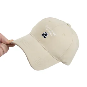 Beige cotton baseball cap with cute bear embroidery and script logo on white background