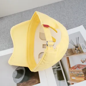 Detail view of a yellow canvas baseball cap showing metal buckle and brand tag