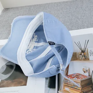 Détail de l'intérieur d'une casquette bleu clair avec bandeau en coton et boucle réglable