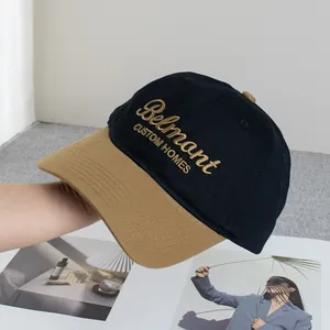 Detalle de gorra de béisbol bicolor negro y marrón con bordado Belmant dorado y costuras