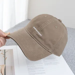Detail of khaki cotton baseball cap showing fine embroidery and stitching on the brim