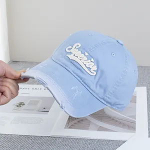 Détail d'une casquette bleue en coton avec broderie Superior 3D et bordure effilochée