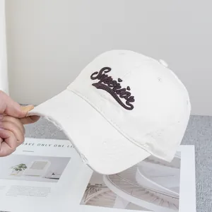 Détail de la casquette vintage en toile beige avec bord usé et broderie Superior chic