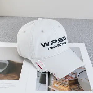 Detail der weißen Vintage-Baseballkappe mit Distressed-Krempe und schwarzer Stickerei
