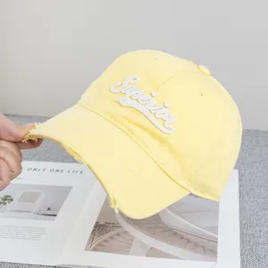 Détail de la broderie 3D Superior et du bord usé sur la casquette jaune clair