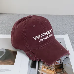 Detail der Distressed-Stickerei auf burgunderroter Basecap mit WPSO-Vintage-Schrift