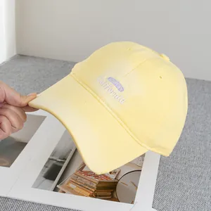 Detailed view of yellow baseball cap with California embroidery and vintage distressed edges