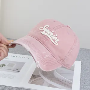 Gros plan détaillé sur une casquette rose en coton avec broderie Superior et effet usé déchiré