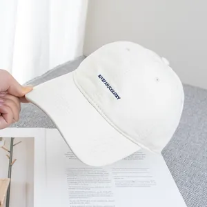 Close-up of the KIVEFAH embroidered logo on a cream canvas baseball cap for women