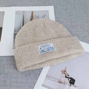 Detail of wool-blend knit beanie showing ribbing texture and rectangular fabric label