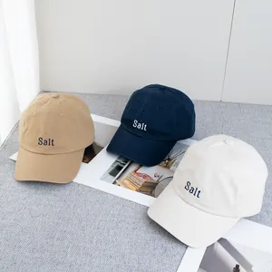 Détail de la broderie Salt sur casquettes en toile de coton kaki, marine et beige