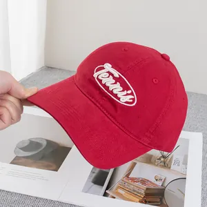 Gros plan sur casquette rouge en coton avec broderie Tennis blanche et visière courbée