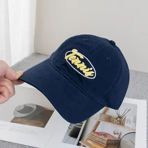 Détail de la broderie jaune Tennis sur la casquette de baseball en toile bleu marine