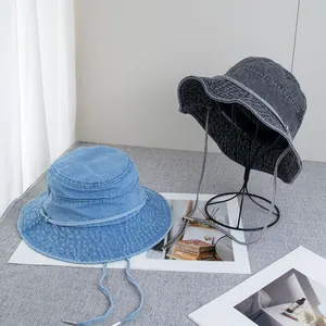 Detail of light blue and dark grey washed denim bucket hats with adjustable straps