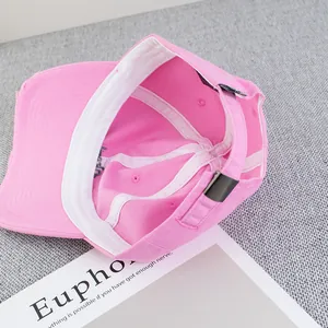 Detail view of pink baseball cap with adjustable metal buckle and inner sweatband