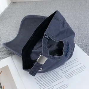 Detail of adjustable metal buckle and blue embroidery on dark gray washed cotton baseball cap