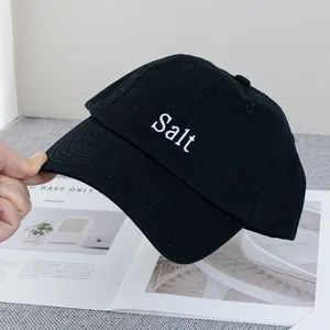 Détail de la broderie blanche Salt et des coutures renforcées sur une casquette en coton noir