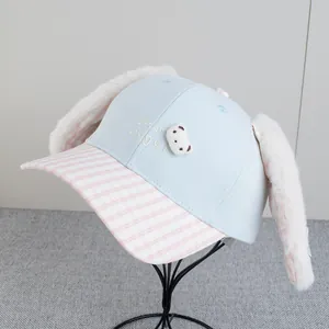 Detail of blue plush baseball cap with long rabbit ears and plaid brim on a display stand
