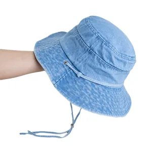 Light blue washed denim bucket hat with decorative straps and adjustable windproof rope
