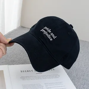 Close-up of black cotton baseball cap featuring white Pride and Prejudice embroidery