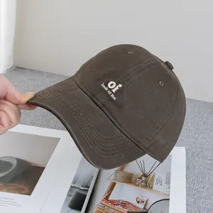 Detailed view of embroidery text and stitch quality on the brown cotton baseball cap