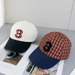 Deux casquettes de baseball en coton avec broderie numéro 3 sur fond de magazine