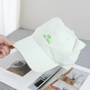 Detail of light green baseball cap featuring cute 3D cat ears and M embroidery