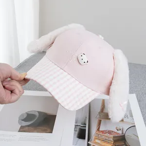 Close-up of pink plush bunny ears and Let's Go embroidery on the cartoon baseball cap