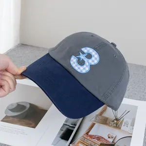 Détail du chiffre 3 brodé en plaid avec étoile sur une casquette de baseball grise