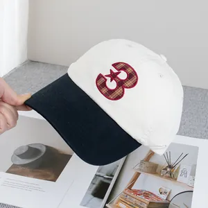Détail de la lettre B brodée en rouge avec tissu écossais sur casquette rétro