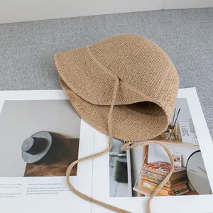 Dettaglio della trama in paglia kaki e del laccio di fissaggio sul cappello da sole