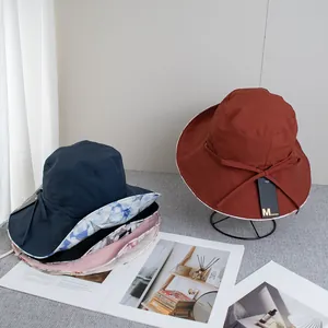 Detail of wide brim sun hats with floral lining and ribbon ties in various colors