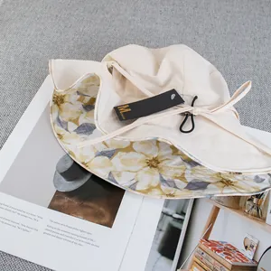 Detail view of beige sun hat with yellow floral lining and adjustable windproof cord