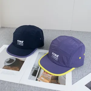 Detail of lightweight ripstop fabric camper hats with embroidered letters and breathable eyelets
