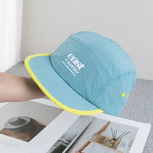 Detailed view of lightweight five-panel camping cap with embroidered letters and contrast brim
