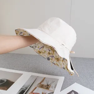 Detail of beige wide brim sun hat showing floral lining and adjustable side straps