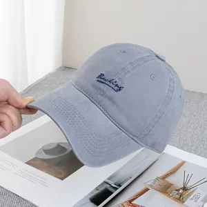 Detail shot of the Backing cursive embroidery on this gray-blue cotton baseball cap
