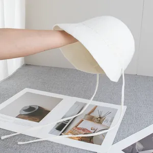 Dettaglio della trama intrecciata e del nastro di questo cappello a secchiello in paglia
