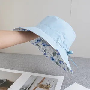 Detail showing blue wide brim sun hat with ribbon bow and floral lining pattern