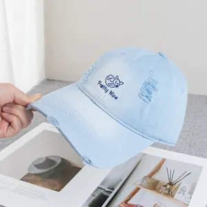 Close-up of distressed light blue cotton baseball cap with embroidered cat and Pretty Nice text
