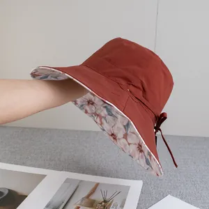 Detail of terracotta sun hat showing floral lining and adjustable bow strap design