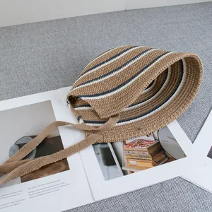 Detail view of striped knit sun hat with chin straps on a vintage magazine backdrop