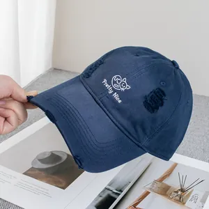 Detail of navy blue distressed baseball cap with cat embroidery and pretty nice text