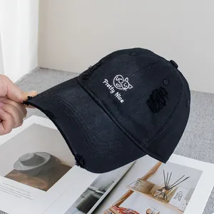 Detailed view of the embroidered cat and Pretty Nice text on a distressed black baseball cap