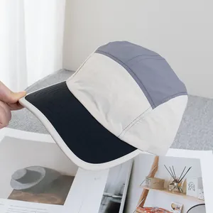 Detail der mehrreihigen Nähte auf der schwarzen flachen Krempe des 5-Panel Camp Hats
