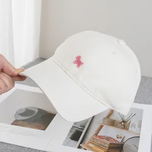 Detailansicht der rosa Welpen-Stickerei auf weißer Baumwoll-Baseballkappe, stilvoll