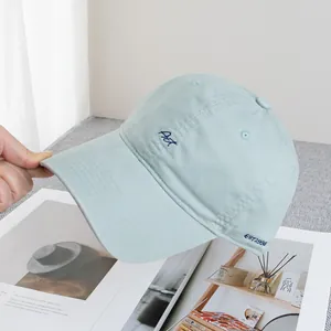 Close-up of light blue cotton baseball cap with dark blue Act and EST 1938 embroidery